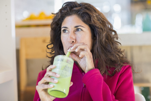 Woman drinking a fruit smoothie through a straw