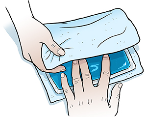 Closeup of woman's hands wrapping ice pack in thin towel.